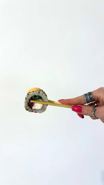 istock Chopsticks holding single sushi isolated on white background 2035168258