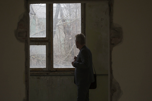 Distraught man inside of ruined abandoned office building