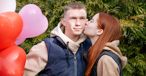 Outdoor photo of happy young woman enjoying date. cheerful romantic couple dating outdoors with balloons