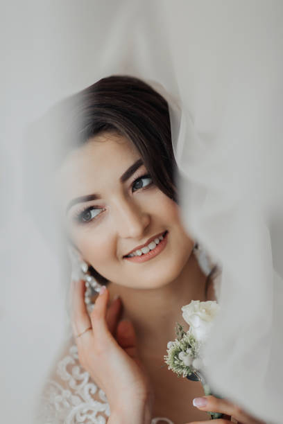 istock A brunette bride in a white dress holds her wedding bouquet 2035270538
