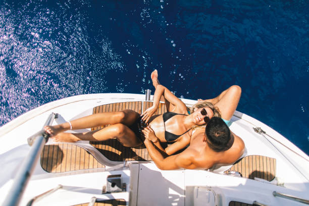 Young couple sitting on a yacht stern while sailing
