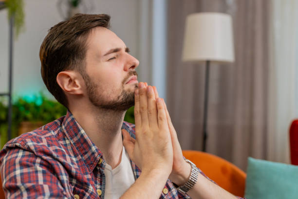 istock Tensed young man folding palms together pray to God ask for help feel stressed looks desperate 2035306098