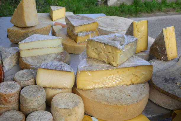istock aged cheese wheels and fresh cheese chunks for sale at a stall 2035328488