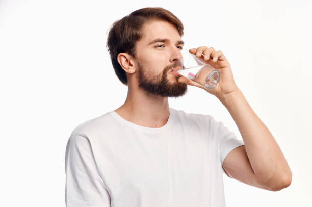 istock handsome man drinking water from a glass surprised look emotions white background 2035328494