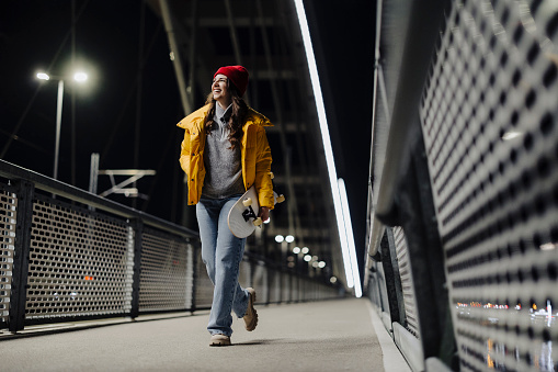 Woman skateboarder on the bridge