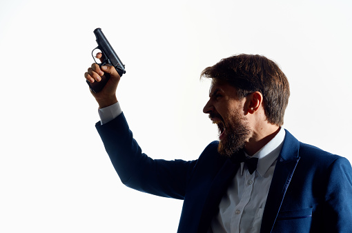 man in suit holding pistol lost his head suicide isolated background. High quality photo