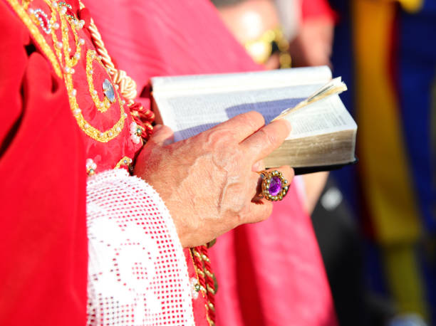 istock bishop with red cassock and the ancient bible with the sacred scriptures in his hand with a ring with red ruby 2035343498