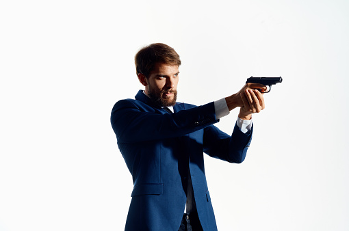 man in suit holding pistol danger gangster murder isolated background. High quality photo