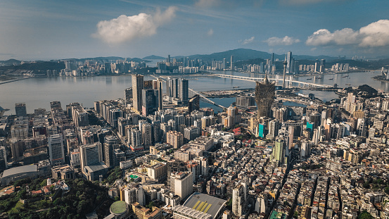 This aerial photo showcases the panoramic view of Macao, featuring a cityscape alongside a body of water.