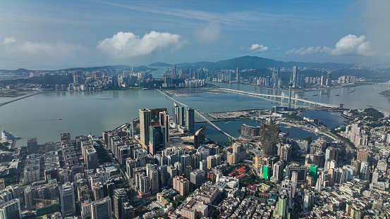 This photo showcases an aerial perspective of Macao, featuring an expansive cityscape and a prominent body of water.