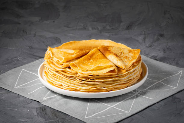 a stack of thin pancakes on a grey table , with copy space for text - blinis photos et images de collection