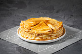 A stack of thin pancakes on a grey table , with copy space for text