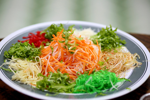 Focus scene on YuSheng ('yee sang' or Prosperity Toss) in Chinese culture.