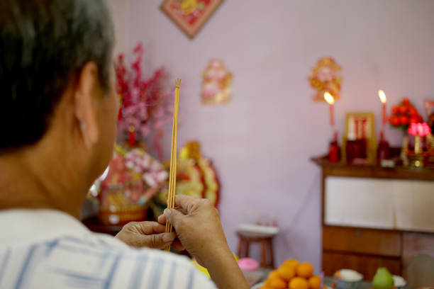 prayers in chinese household - praying figurine people men стоковые фото и изображения