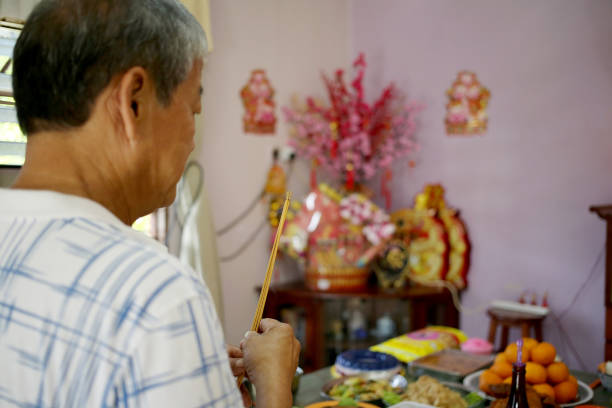 prayers in chinese household - praying figurine people men стоковые фото и изображения