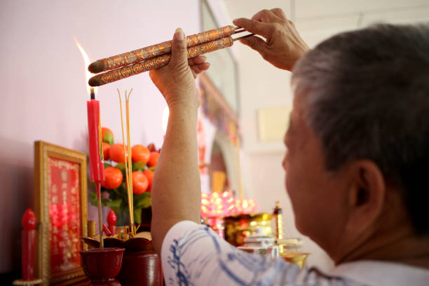 prayers in chinese household - praying figurine people men стоковые фото и изображения