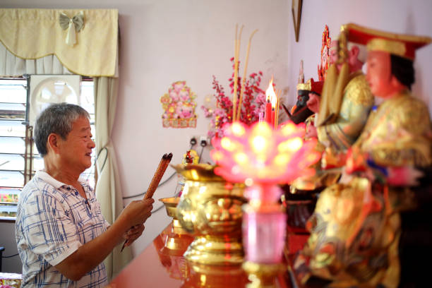 prayers in chinese household - praying figurine people men стоковые фото и изображения