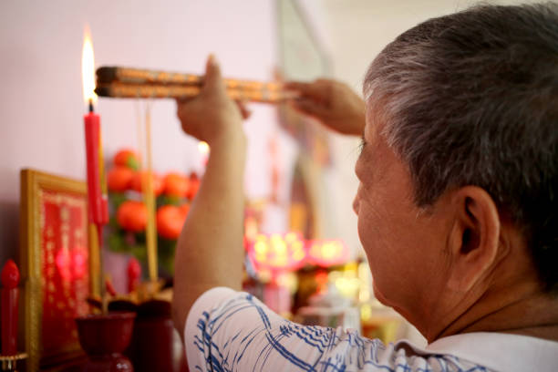 prayers in chinese household - praying figurine people men стоковые фото и изображения