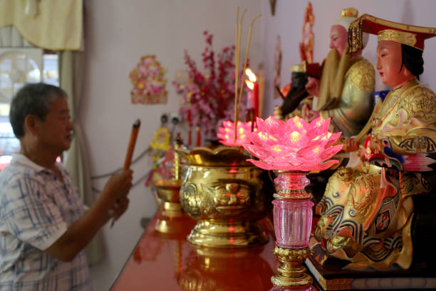 prayers in chinese household - praying figurine people men стоковые фото и изображения