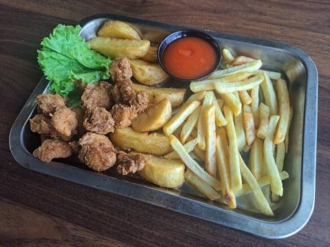 Delicious A Snack Platter On Tray With French Fries, Potato Wedges, Chicken Pop And Mix Salad. Food Menu.