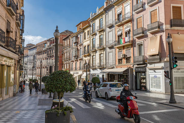 Granada, Spain. January 10th, 2023. Busy day at the street Reyes Catalicos with scooters, taxi and pedestrians.