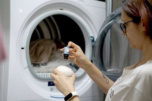 Woman putting scent balls into the washing machine
