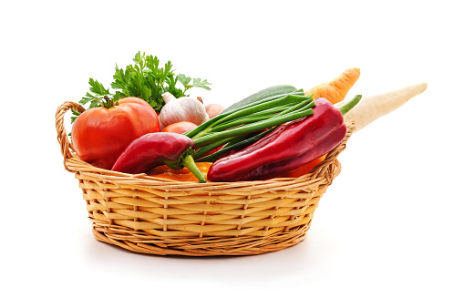 Vegetables in a basket isolated on a white background.