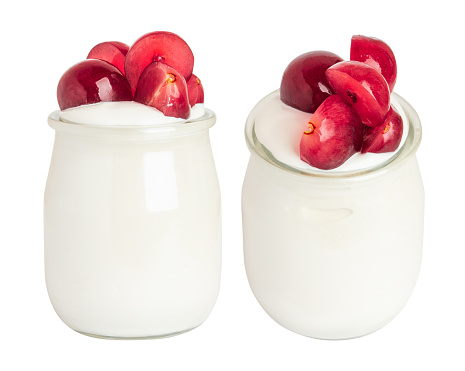 yogurt with grapes in a small glass jar. On a blank background