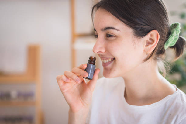 istock Smiling young woman smeling essential oil 2035354763