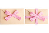 Pink envelope with a bow on a blank background.