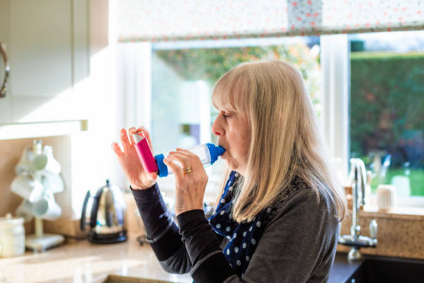 istock Asthmatic senior woman using asthma inhaler at home 2035363134