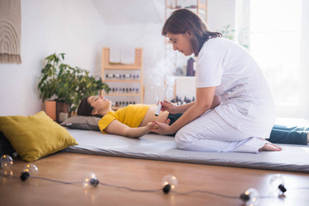 young woman enjoying moxibustion therapy - chinese medicine homeopathic medicine herbal medicine doctor fotografías e imágenes de stock