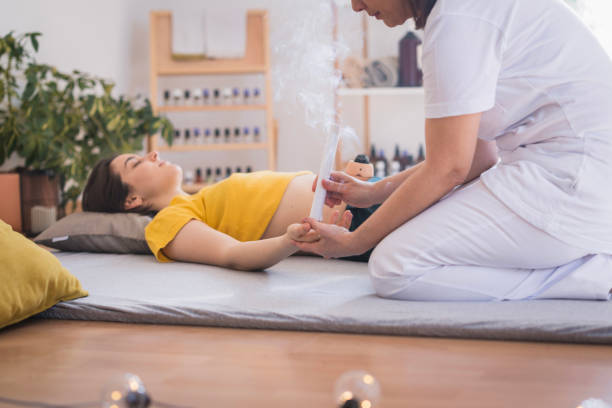 young woman enjoying moxibustion therapy - chinese medicine homeopathic medicine herbal medicine doctor foto e immagini stock