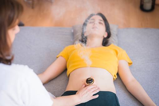 Woman undergoing moxibustion therapy