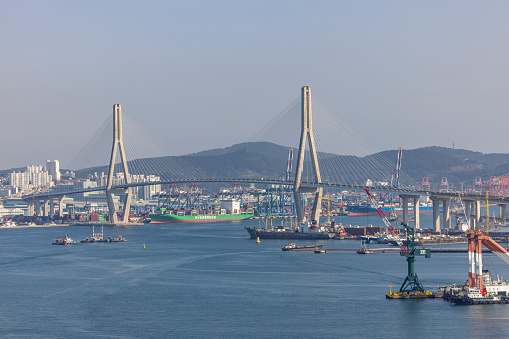 busan, south korea - november 1, 2023: busan harbor bridge and huge industrial harbor in busan city, south korea.