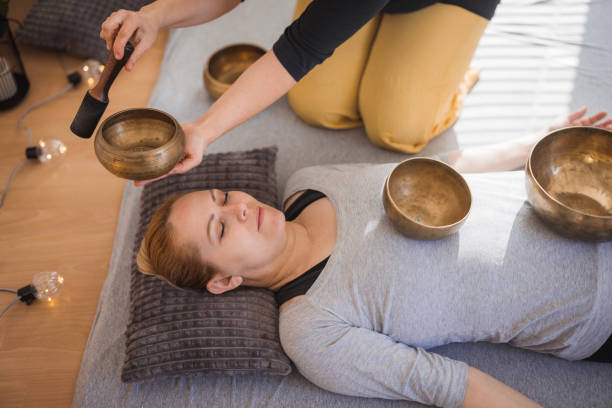 istock Woman curing headache with Tibetan singing bowls 2035382053