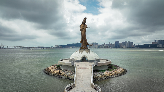 Macao, China - May 12, 2023: Aerial view of the monumental Guan Yin statue, proudly positioned in the middle of the body of water in Macau.