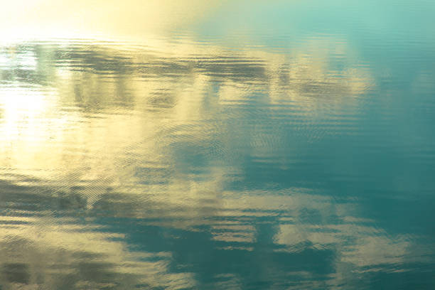 Reflection of sky and clouds on water surface. Abstract background.
