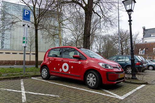 Utrecht, the Netherlands. 10 February 2024. Red Greenwheels car on the street in Utrecht. Renting a car is easy with Greenwheels. you will find a shared car within walking distance.