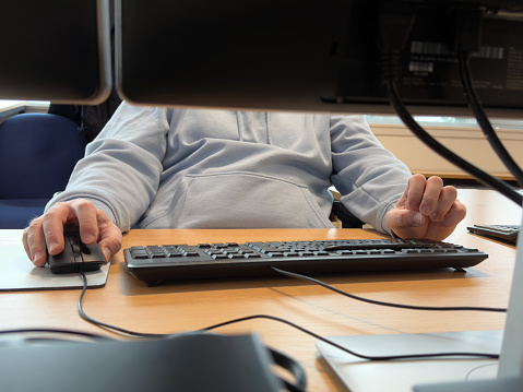 Office worker using computer at desk UK