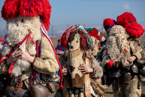 Elin Pelin, Bulgaria - February 17, 2024: Eighth edition of masquerade festival in Elin Pelin Bulgaria. Men dressed in kuker costume with copper bells perform a ritual for fertility and health.