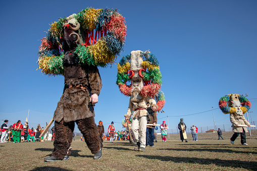 Elin Pelin, Bulgaria - February 17, 2024: Eighth edition of masquerade festival in Elin Pelin Bulgaria. Men dressed in kuker costume with copper bells perform a ritual for fertility and health.