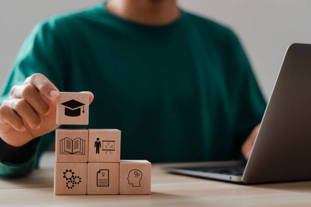 istock Businessman stacking wooden blocks with learning icons for online education concept, E-learning education, internet lessons and online webinar. 2035479023