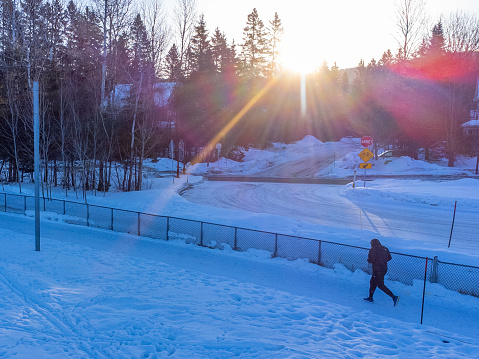 Side view of black man jogging outside in a public park during winter day