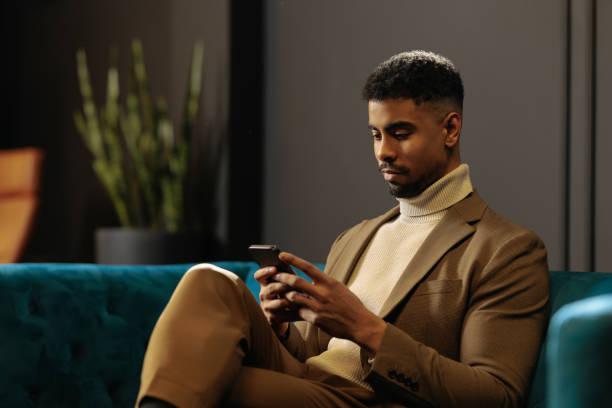 Businessman chilling on the sofa and texting at work