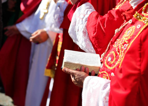 istock elderly bishop with red cassock and Bible in hand during the religious rite 2035509672