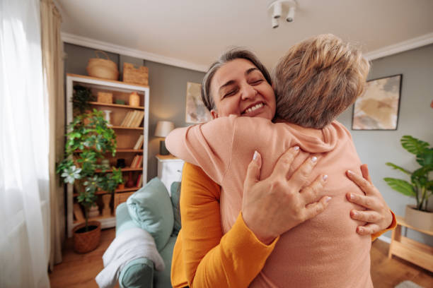 istock Two older women hugging and smiling at home 2035522616