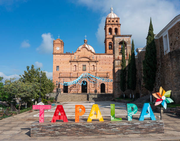View from the street below of the The Church of Our Lady of Guadalupe with colorful flags strung across on a sunny morning in Puerto Vallarta Mexico.