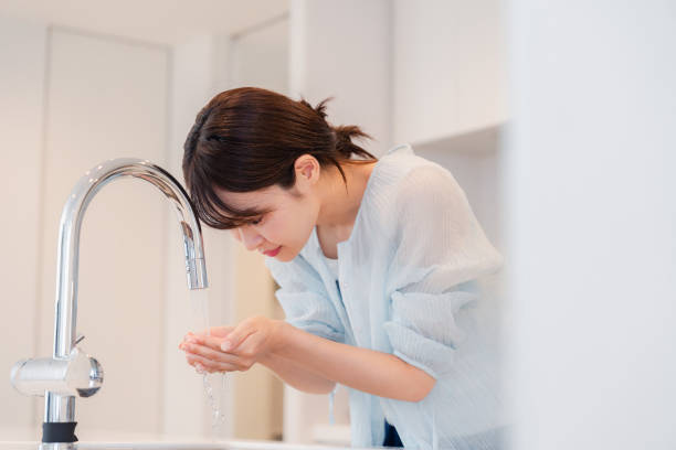 istock Young woman washing her face at home 2035540784