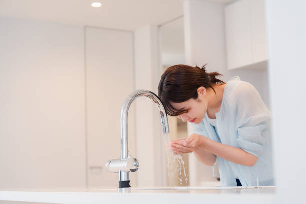 istock Young woman washing her face at home 2035540798
